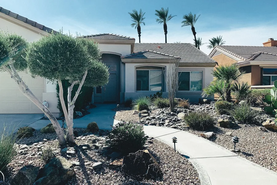 A xeriscaped front yard with gravel and desert planting
