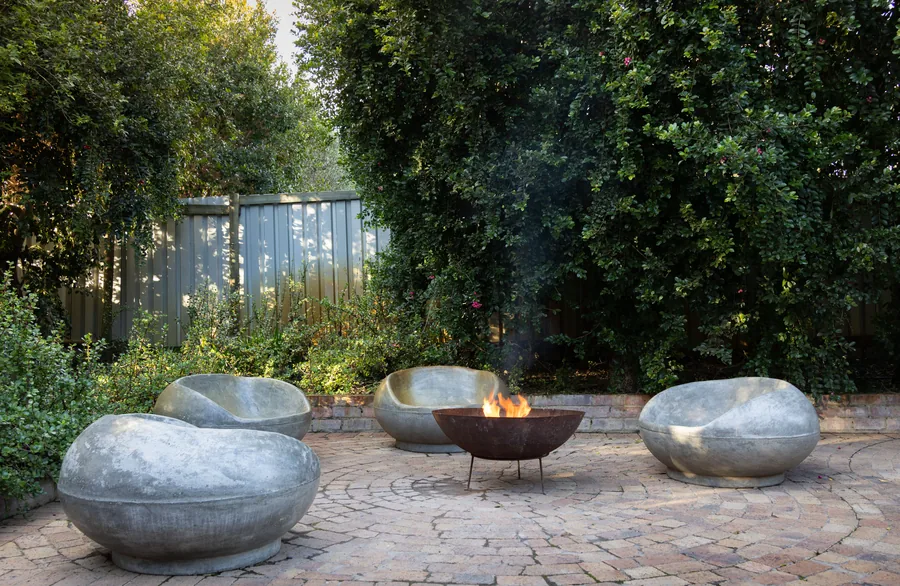 A fire pit with stone seating in a finished backyard